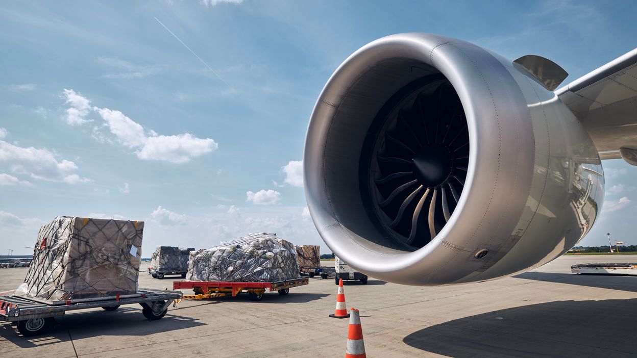 Air cargo pallets being loaded alongside a widebody aircraft